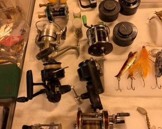 collection of vintage fishing reels and tackle from brands such as Garcia Mitchell, Penn, and Daiwa