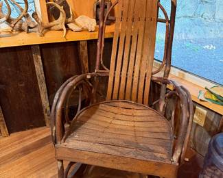 This is a rustic Amish hickory twig rocking chair featuring bent hickory branches for the frame and oak slats for the seat and back