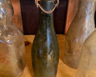 vintage green glass bottle, likely German, featuring a traditional "plop top" or "bail top" mechanism with a wire clamp