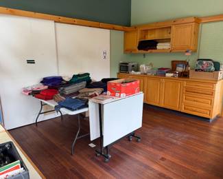 Incredible sewing room filled with fabric, sewing machines, findings, sewing and crafting books, etc