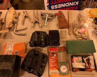 various vintage items, including old fishing lures, binoculars, tools, and a wooden fish decoy
