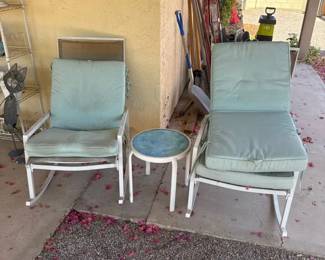 A Couple Metal Rocking Chairs And A Table
