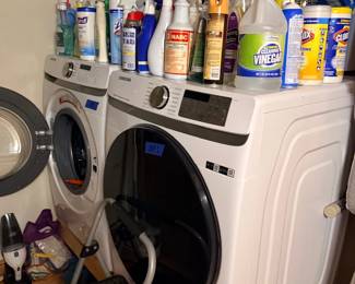 Front load washer and dryer set with cleaning supplies
