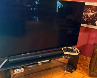 Large flat screen TV with sound bar and stand