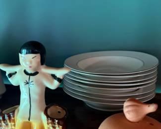 Vintage ceramic figurine and stack of dinner plates