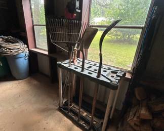 Garden Tool Rack with Various Tools - A sturdy garden tool rack holding various gardening tools including rakes and shovels. Ideal for organizing your gardening equipment.