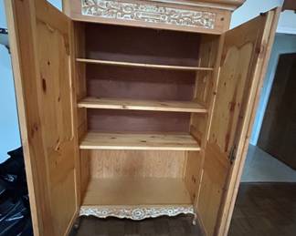 Vintage Wooden Armoire with Carved Details - This charming vintage armoire features intricate carvings and ample shelving space, perfect for storage or display. Ideal for any rustic or traditional decor.