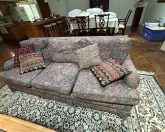 Floral Pattern Sofa with Decorative Pillows - A comfortable floral pattern sofa featuring several decorative pillows. Ideal for adding a cozy touch to your living space.