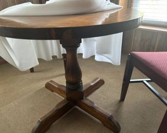 Round Wooden Dining Table - A charming round wooden dining table with a sturdy base, perfect for small spaces. Ideal for casual dining or as a decorative piece.