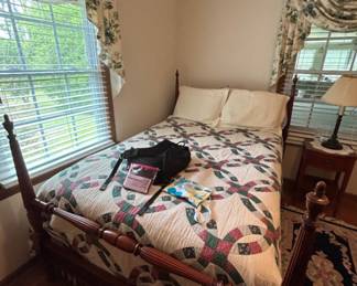 Vintage Wooden Bed Frame with Quilt - A charming vintage wooden bed frame featuring a colorful quilt. Perfect for adding a classic touch to any bedroom.