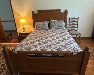 Vintage Wooden Bed Frame with Quilt and Pillows - A charming vintage wooden bed frame featuring a quilted bedspread and decorative pillows. Perfect for adding a classic touch to any bedroom.