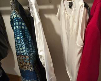Assorted Women's Clothing - A collection of women's tops including a patterned blouse and a white shirt. Perfect for casual or professional wear.
