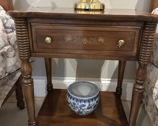 Wooden nightstand with inlay, spindle legs, brass lamp, ceramic pot