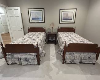 Pair of wooden twin beds with nightstand and lamp
