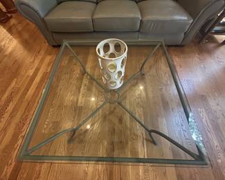Glass-top iron coffee table with decorative candle holder vase