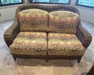 Wicker loveseat, tapestry cushions, floral pattern upholstery