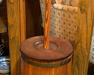 antique, primitive wooden barrel butter churn often featuring metal bands for reinforcement