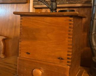 antique hand-crank coffee grinder, likely made of wood with dovetail joint construction