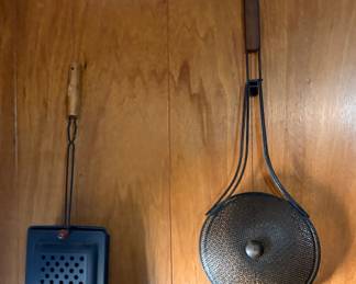 vintage Androck campfire popcorn popper, often used as a fireplace tool or for roasting nuts