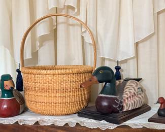 vintage Nantucket lightship basket featuring a traditional rattan weave, curved wooden swing handle, and a solid wooden base with canvas liner & duck decor 