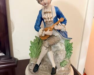 vintage Dresden-style porcelain figurine of a boy playing a mandolin, featuring intricate lace detailing on his sleeves
