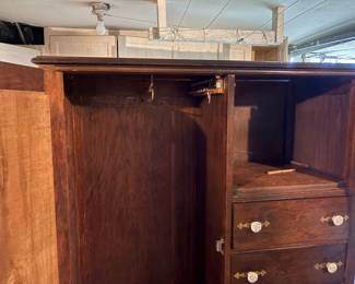 antique chifforobe features a mirrored wardrobe door and several small drawers with distinctive white knobs