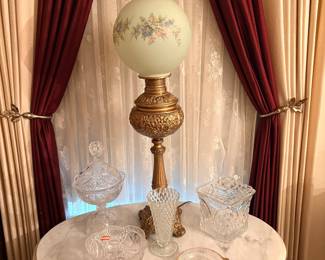 Victorian banquet lamp features an ornate brass base and a hand-painted floral milk glass globe, glass decor & marble sofa table