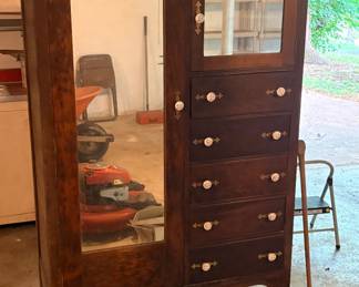antique chifforobe features a mirrored wardrobe door and several small drawers with distinctive white knobs