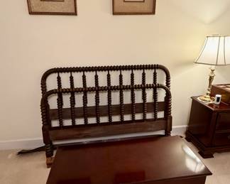 Antique spindle bed behind chest.