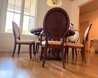 Round pedestal dining table with oval-back upholstered chairs