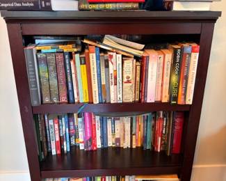Wood bookcase filled with books, hardcovers and paperbacks