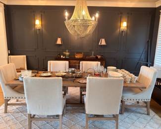 Dining table with upholstered chairs and beaded chandelier