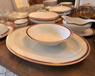 Brown-rimmed china service with plates and gravy boat