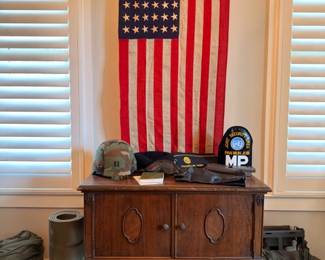 Vintage 48-star American flag with antique oak sideboard and WWII militaria
