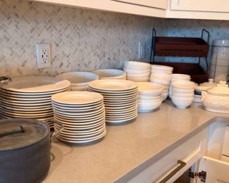 Stacks of white dishes, plates, and bowls