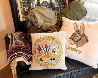 US Army needlepoint pillows on black leather armchair