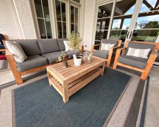 Teak patio furniture set with gray cushions and coffee table