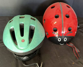 Lot 34: Green Schwinn bicycle helmet and red ladybug helmet
