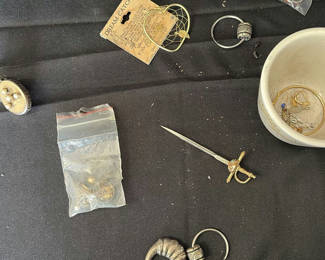 Lot 27: Assorted jewelry and small trinkets including a miniature sword pendant