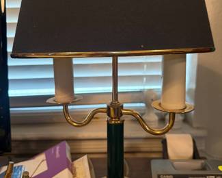  features a polished brass base with curved arms and a green-painted column, 