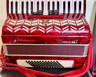 Parrot Piano Accordion – Vintage red pearloid piano accordion with approximately 26 keys and 48 bass buttons. Includes shoulder straps. Attractive decorative grille and classic mid-century styling