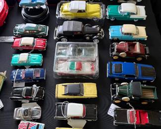Collection of vintage and collectible die-cast model cars featuring classic American automobiles, antique cars, convertibles, muscle cars, trucks, and specialty vehicles. Includes several boxed and tagged examples in a variety of scales
