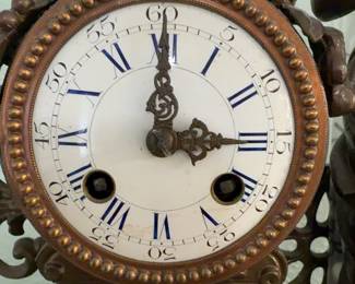 Antique French Figural Mantel Clock featuring a young woman reading beside a spinning wheel atop a white marble base with ornate bronze-finished spelter mounts. Houses an 8-day French time and strike movement by Grivolat Frères Aînés. Circa 1880–1900