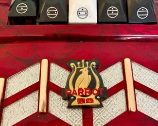 Parrot Piano Accordion – Vintage red pearloid piano accordion with approximately 26 keys and 48 bass buttons. Includes shoulder straps. Attractive decorative grille