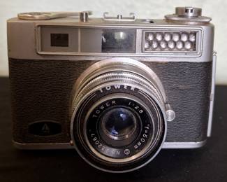 Tower 57-A 35mm rangefinder camera featuring a Tower 50mm f/2.8 lens with manual focus and exposure controls. Classic mid-century camera with a metal body