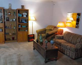 La Z Boy overstuffed arm chair, love seat with twin size pull out, book case, table lamp, floor lamp, tall cabinets, coffee table chest, clocks, pottery