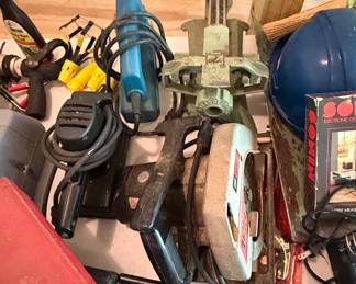 Assorted Power Tools: Skil Circular Saw, Blue Handheld Tool, and Green Vise