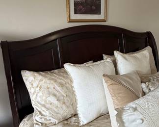 Dark Wood Sleigh Bed Frame with Decorative Pillows and Framed Art