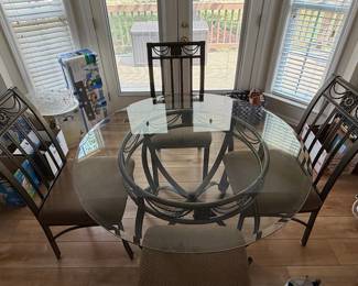 Round Glass Top Dining Set with Scrolled Metal Base and Chairs