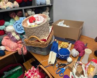 Sewing items, baskets, lots of knitting needle pairs, thread, buttons, etc...